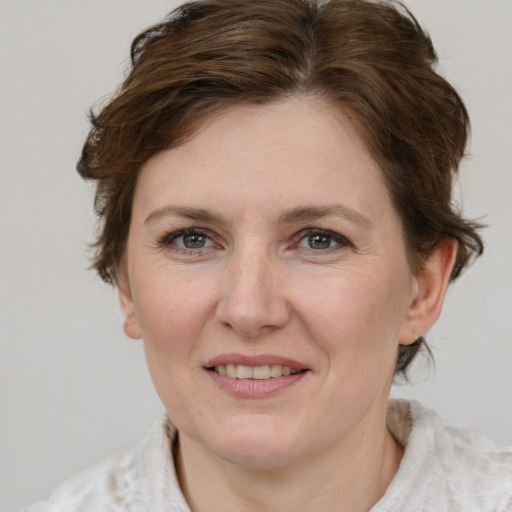 Joyful white young-adult female with medium  brown hair and blue eyes