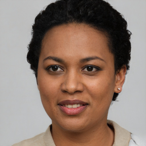 Joyful black young-adult female with short  black hair and brown eyes