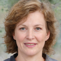 Joyful white adult female with medium  brown hair and blue eyes