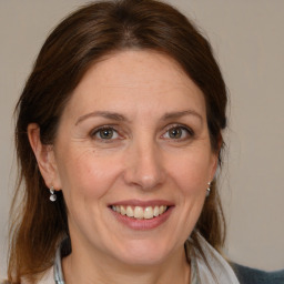 Joyful white adult female with medium  brown hair and brown eyes