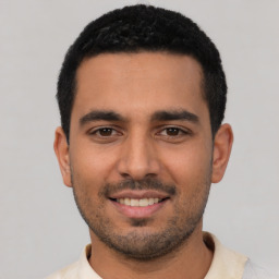 Joyful latino young-adult male with short  black hair and brown eyes