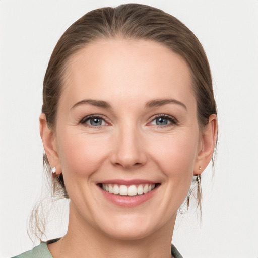 Joyful white young-adult female with medium  brown hair and grey eyes