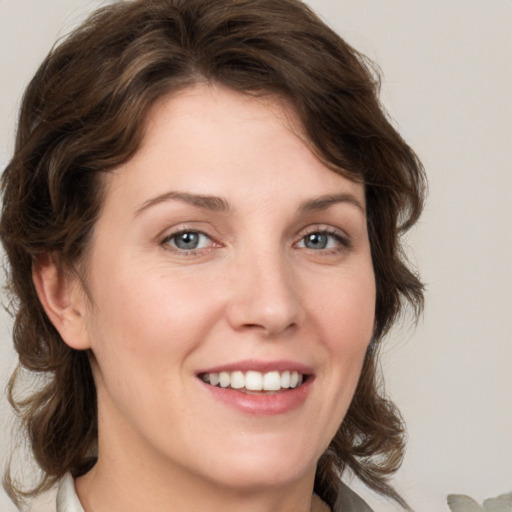 Joyful white young-adult female with medium  brown hair and green eyes