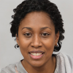 Joyful black adult female with short  black hair and brown eyes