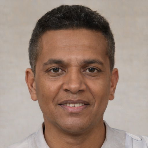 Joyful black adult male with short  brown hair and brown eyes