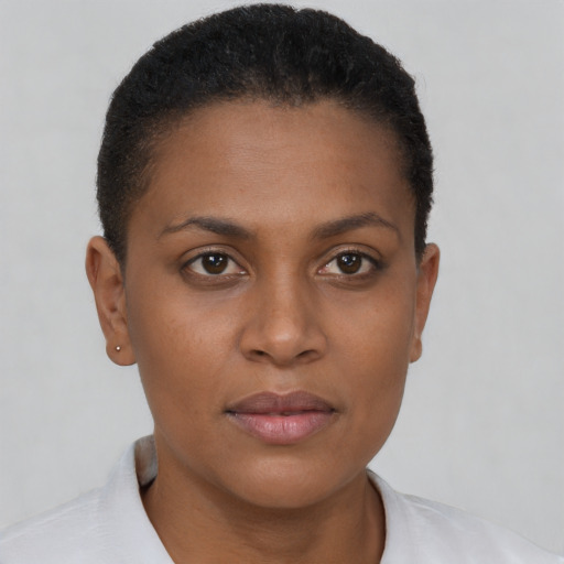 Joyful black young-adult female with short  brown hair and brown eyes