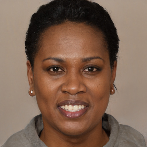 Joyful black adult female with short  black hair and brown eyes