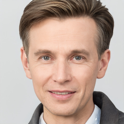 Joyful white adult male with short  brown hair and grey eyes