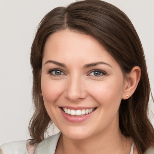 Joyful white young-adult female with medium  brown hair and grey eyes