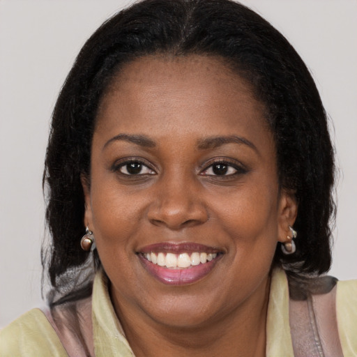 Joyful black young-adult female with long  brown hair and brown eyes