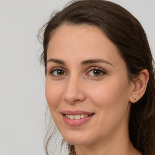 Joyful white young-adult female with long  brown hair and brown eyes