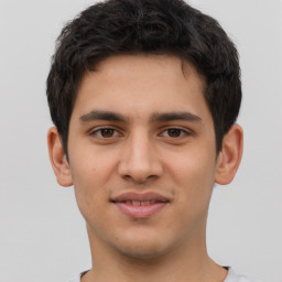 Joyful latino young-adult male with short  brown hair and brown eyes