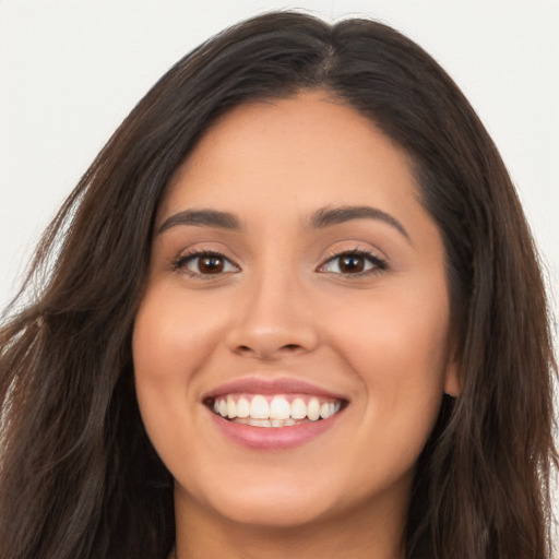 Joyful latino young-adult female with long  brown hair and brown eyes