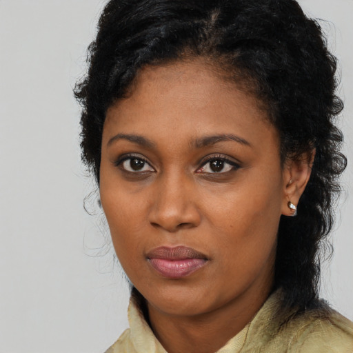 Joyful black young-adult female with long  black hair and brown eyes