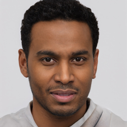 Joyful black young-adult male with short  black hair and brown eyes