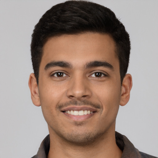 Joyful latino young-adult male with short  brown hair and brown eyes