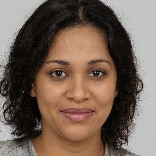 Joyful black young-adult female with medium  brown hair and brown eyes