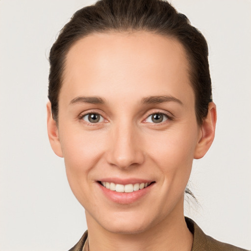 Joyful white young-adult female with short  brown hair and grey eyes