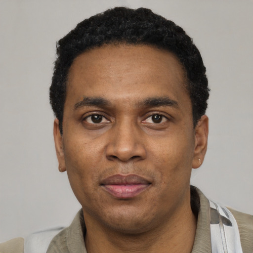 Joyful black adult male with short  black hair and brown eyes
