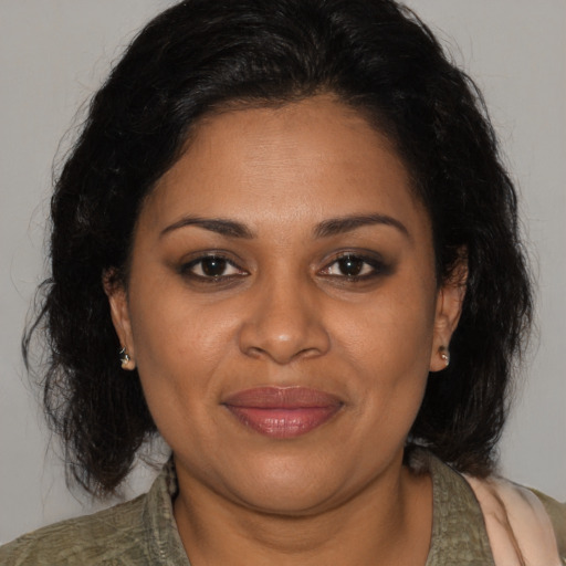 Joyful black adult female with medium  brown hair and brown eyes