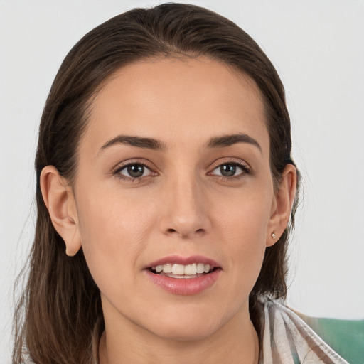 Joyful white young-adult female with medium  brown hair and grey eyes