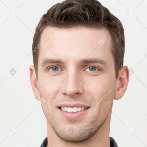 Joyful white young-adult male with short  brown hair and grey eyes