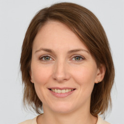 Joyful white young-adult female with medium  brown hair and grey eyes