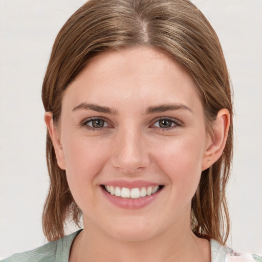 Joyful white young-adult female with medium  brown hair and grey eyes