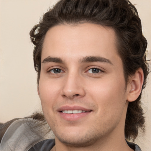 Joyful white young-adult male with medium  brown hair and brown eyes