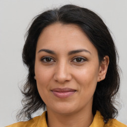 Joyful latino adult female with medium  brown hair and brown eyes