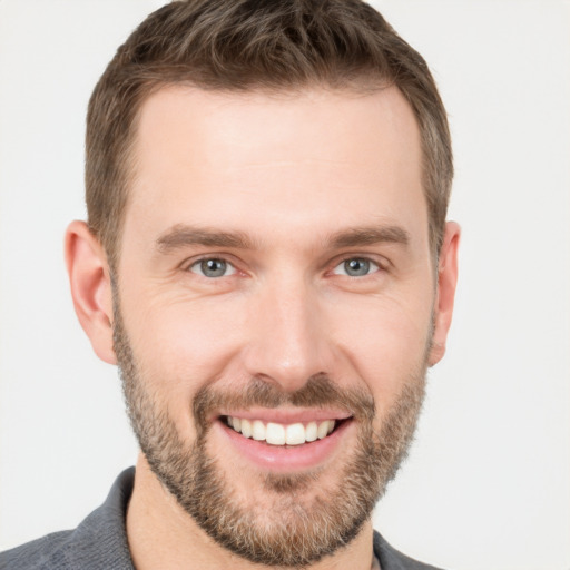 Joyful white young-adult male with short  brown hair and grey eyes