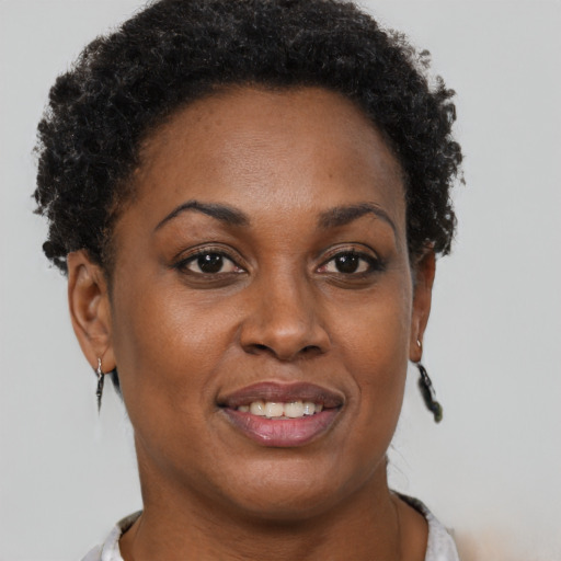 Joyful black adult female with short  brown hair and brown eyes