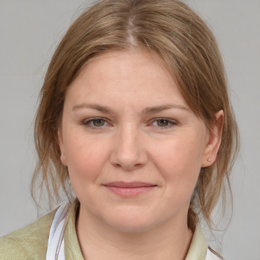 Joyful white young-adult female with medium  brown hair and blue eyes