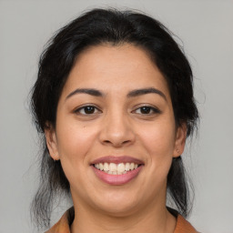 Joyful latino young-adult female with medium  brown hair and brown eyes