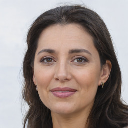 Joyful white adult female with long  brown hair and brown eyes