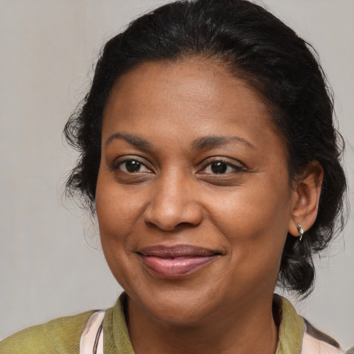 Joyful black adult female with medium  brown hair and brown eyes
