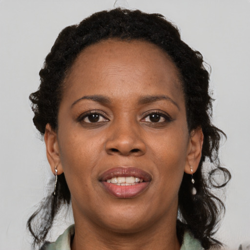 Joyful black adult female with medium  brown hair and brown eyes