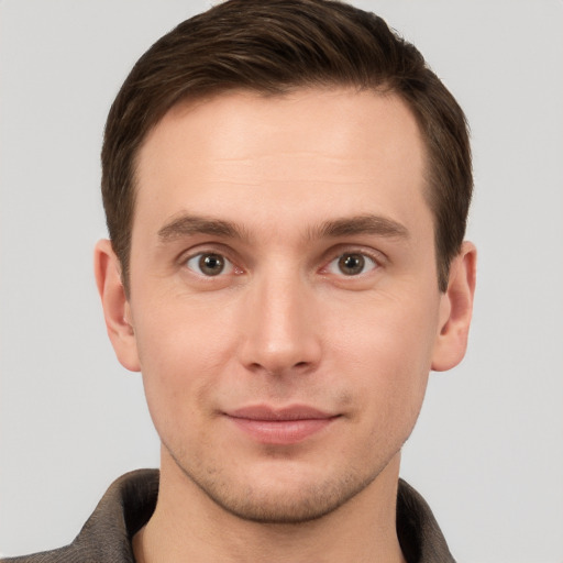 Joyful white young-adult male with short  brown hair and grey eyes