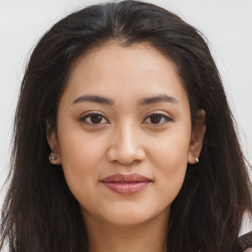 Joyful latino young-adult female with long  brown hair and brown eyes