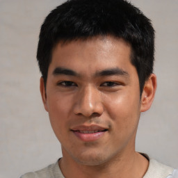 Joyful asian young-adult male with short  black hair and brown eyes