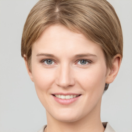 Joyful white young-adult female with short  brown hair and grey eyes