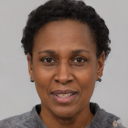 Joyful black adult female with short  black hair and brown eyes