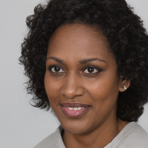 Joyful black young-adult female with medium  black hair and brown eyes