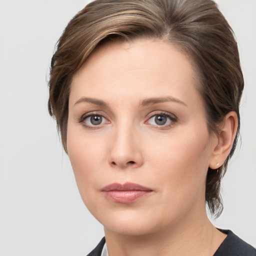 Joyful white young-adult female with medium  brown hair and grey eyes