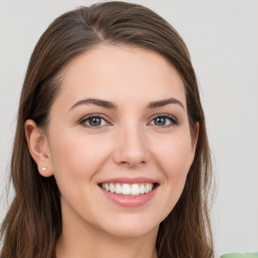 Joyful white young-adult female with long  brown hair and grey eyes