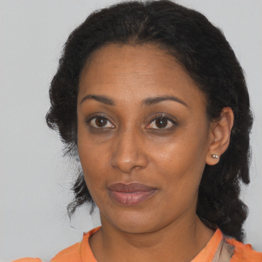 Joyful black adult female with medium  brown hair and brown eyes