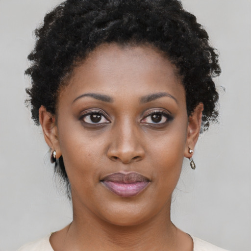 Joyful black young-adult female with short  black hair and brown eyes