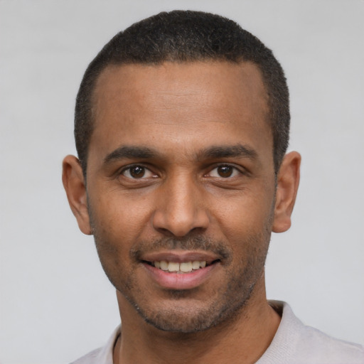 Joyful latino young-adult male with short  black hair and brown eyes