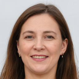 Joyful white adult female with long  brown hair and grey eyes