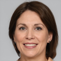 Joyful white adult female with medium  brown hair and grey eyes